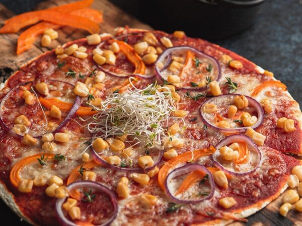 A delicious vegetarian pizza with corn and red onions