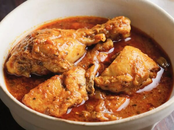 Chicken curry in a white bowl with sauce