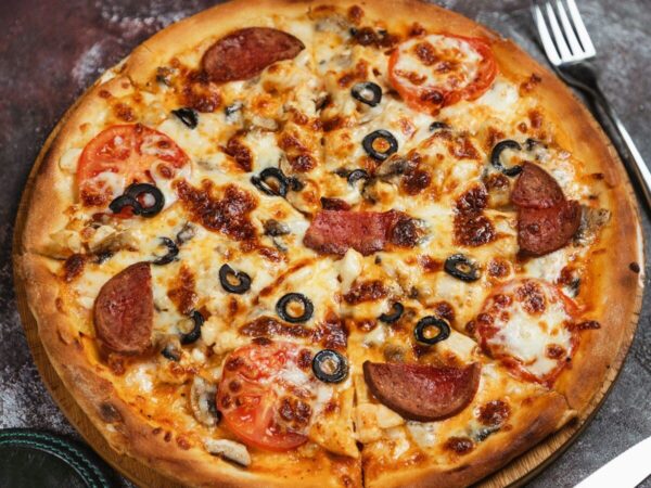 a pizza sitting on top of a wooden cutting board